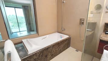 A modern bathroom with a glass-enclosed shower, a freestanding bathtub, and a large mirror.