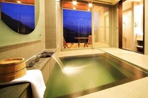 A modern spa room with a large bathtub, wooden bath tubs, and a view of the evening sky. - Cedarwood Villa (Taian)