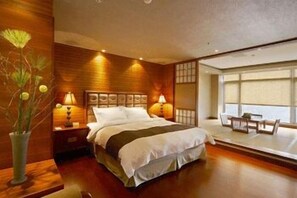 A modern hotel room with a large bed, bedside lamps, a wooden accent wall, and a view of the outdoors. - Cedarwood Villa (Taian)