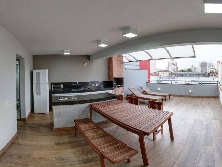 Une cuisine moderne dotée d’un four encastré et d’un coin repas avec une table et un banc en bois.