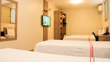 Quarto de hotel com duas camas, televisão, espelho e guarda-roupa.