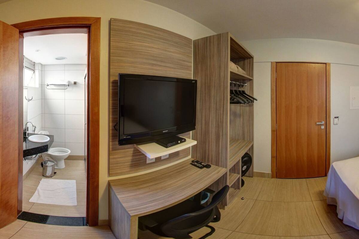 Ett hotellrum med TV, en säng, ett badrum och en garderob.