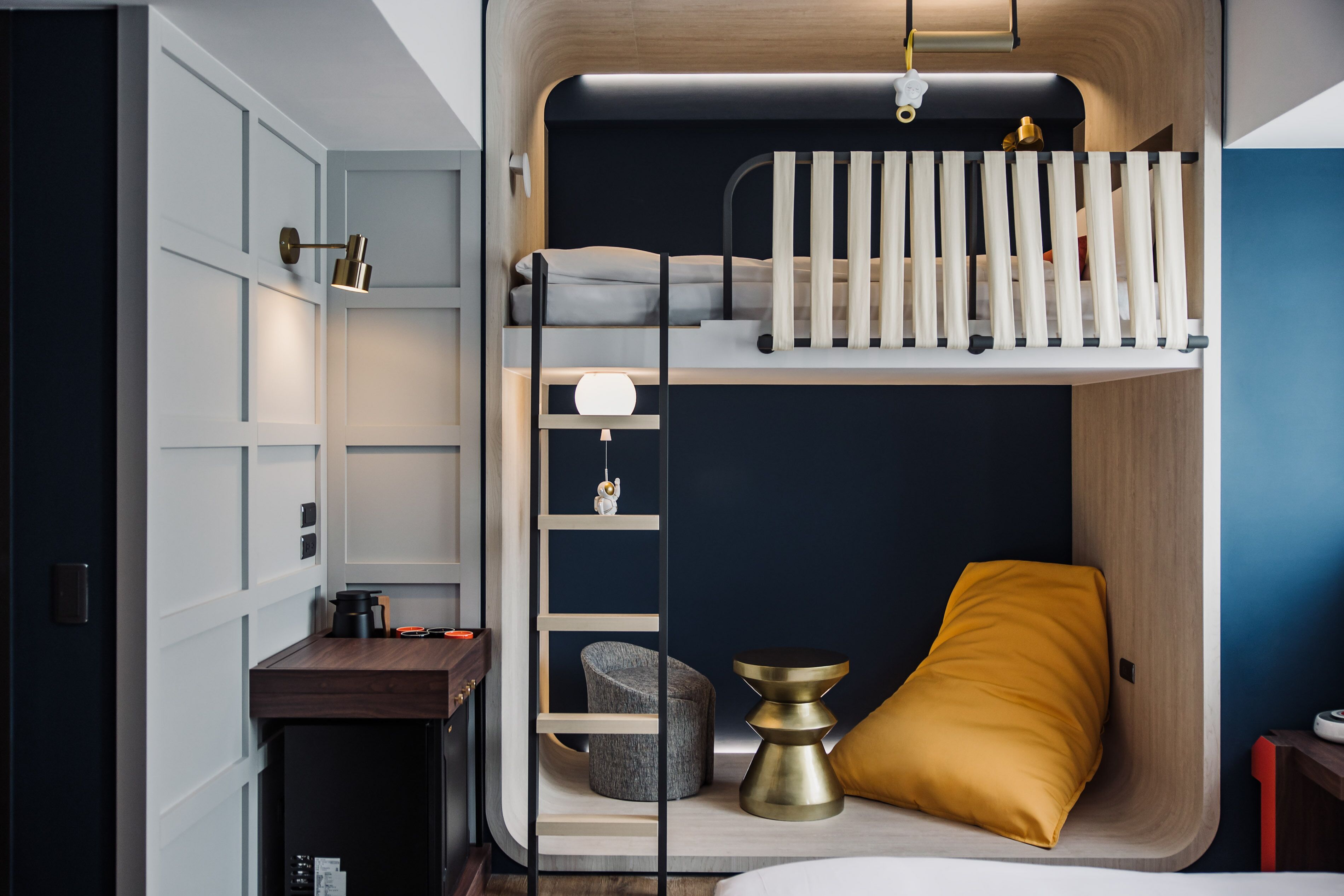 A compact room with a bunk bed, a desk, and a chair.