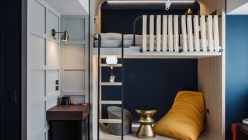 A compact room with a bunk bed, a desk, and a chair.