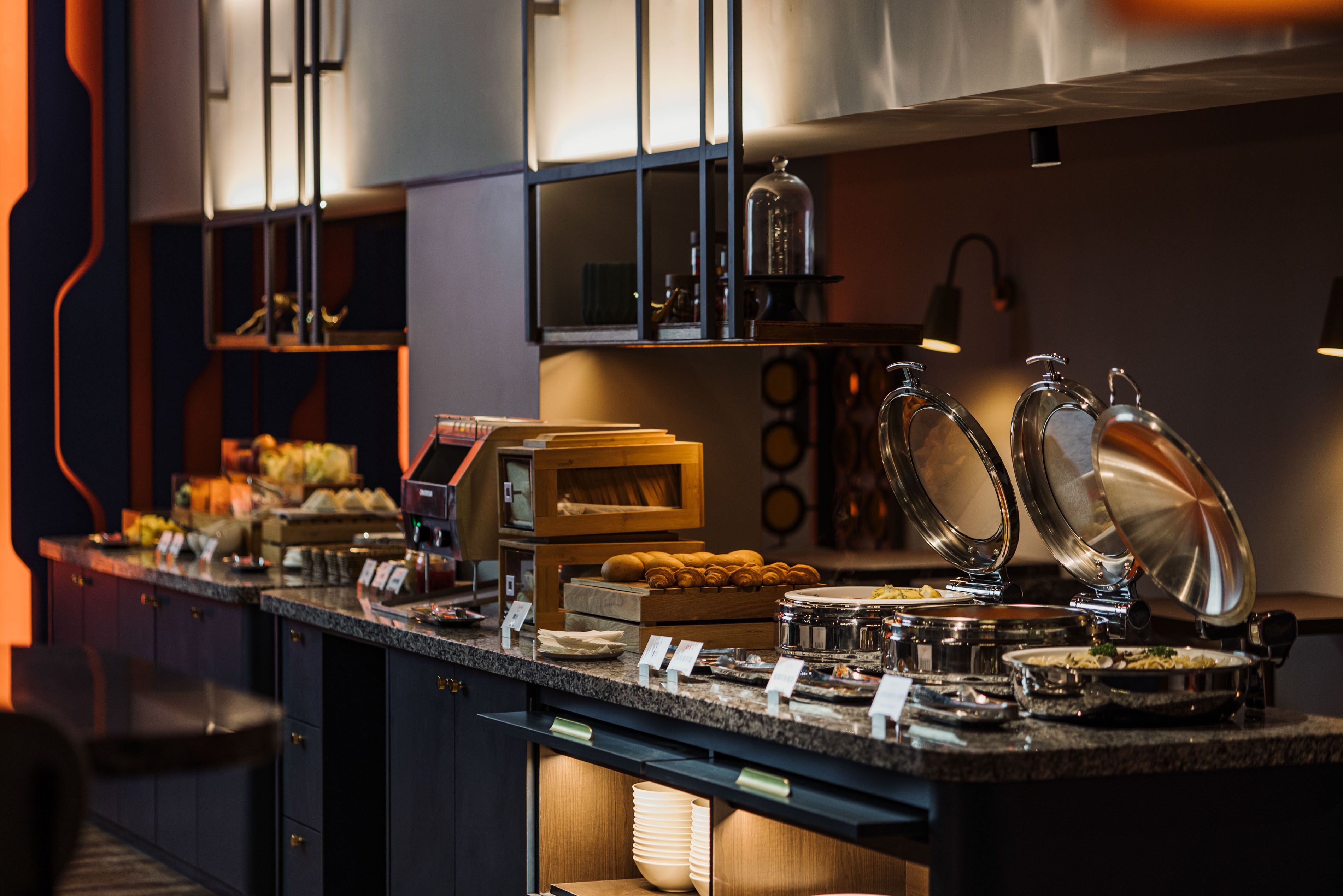 A buffet setup with various food items and serving utensils.