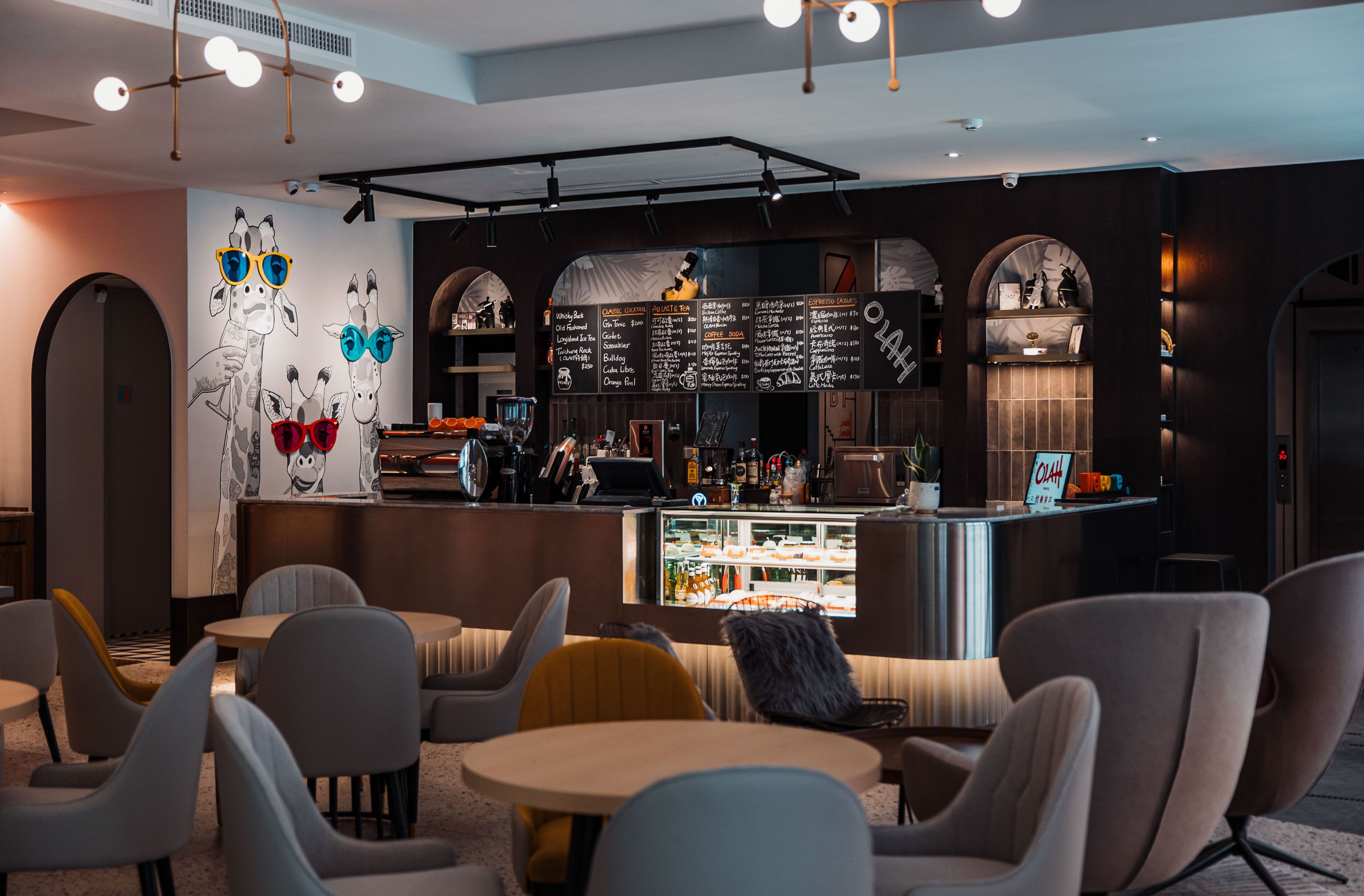 A modern cafe with a counter, menu board, and seating area.