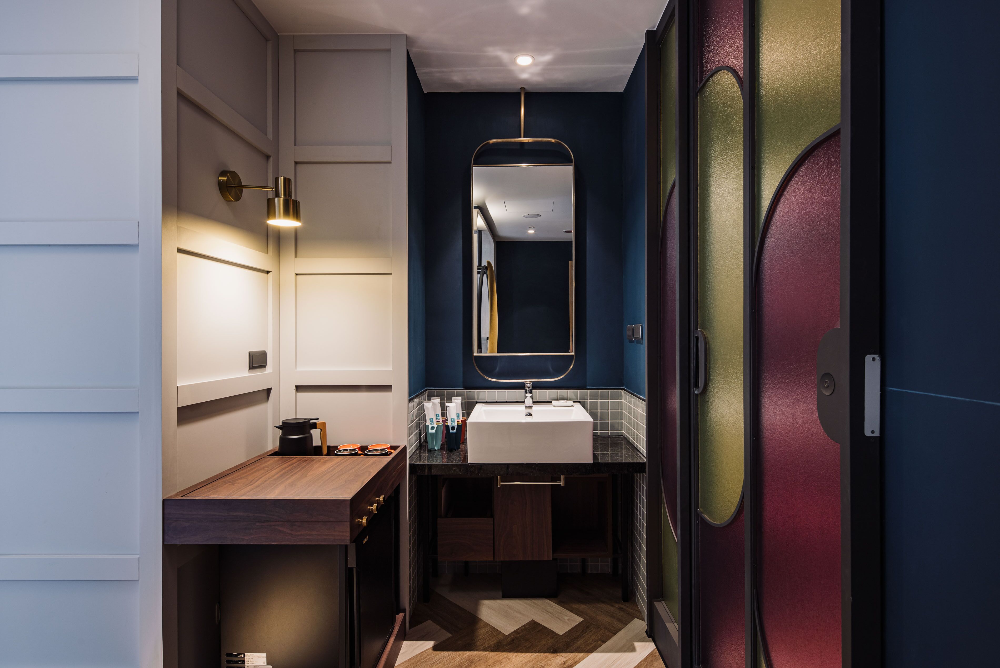 A modern bathroom with a wooden vanity, a white sink, and a mirror above it.