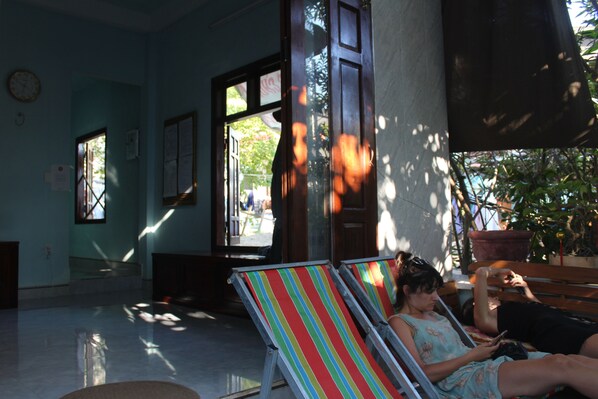 A room with a large window, a door, and a bench.
