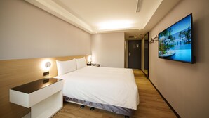 A modern hotel room with a large bed, bedside table, and a flat-screen TV mounted on the wall. - HUB Hotel Tucheng (New Taipei City)