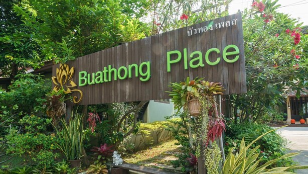A wooden sign with "Buathong Place" written on it, surrounded by various potted plants and greenery. - Buathong Place (Koh Samui)