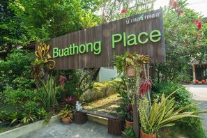 A wooden sign with "Buathong Place" written on it, surrounded by various potted plants and greenery. - Buathong Place (Koh Samui)