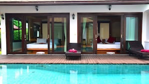 Hotel com piscina, dois quartos com camas e um banco.
