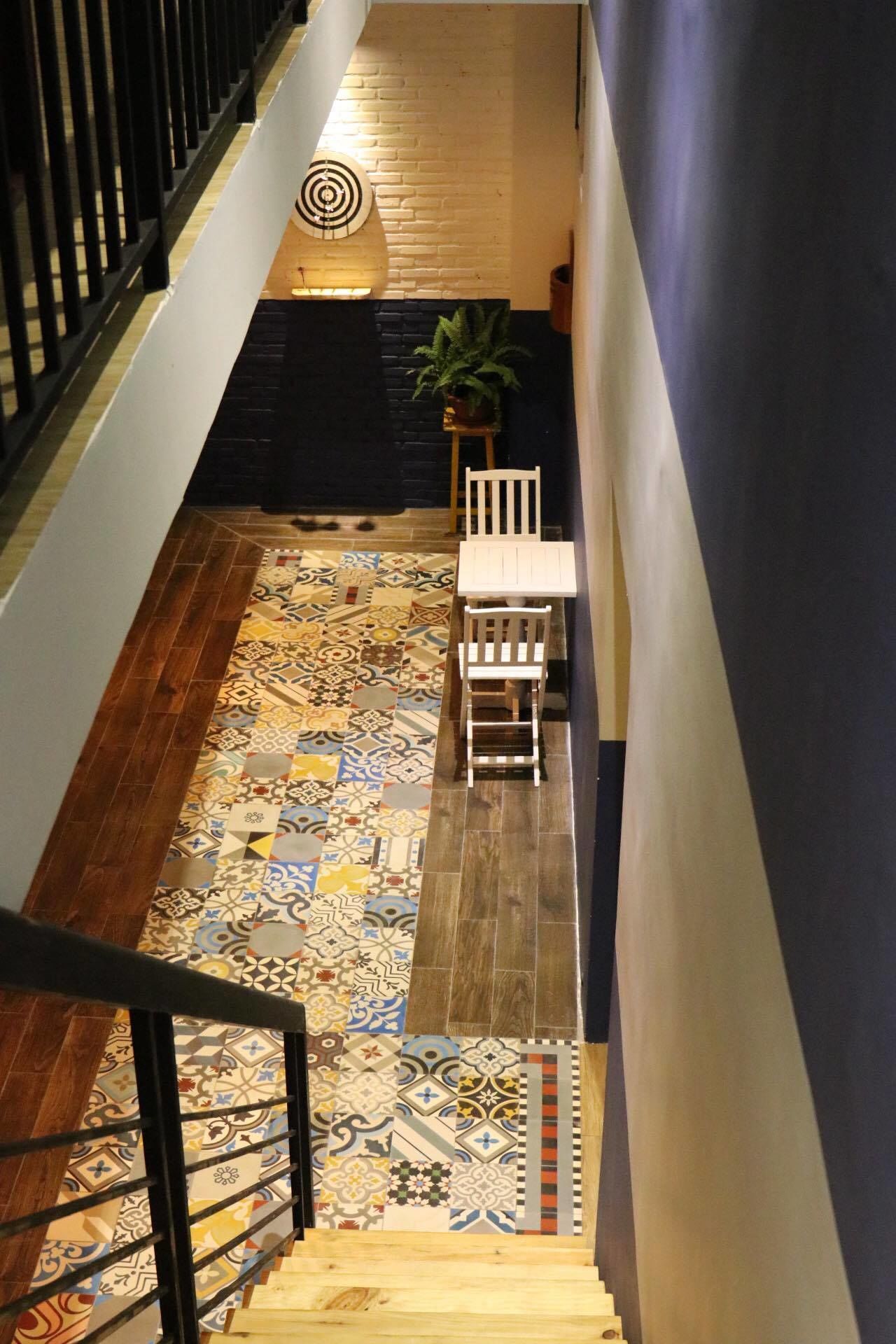 A staircase with a patterned floor leading to a landing.