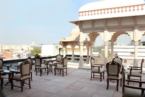 A rooftop terrace with traditional Indian-style seating and a decorative pavilion. - Hotel Mumtaz Mahal (Agra)