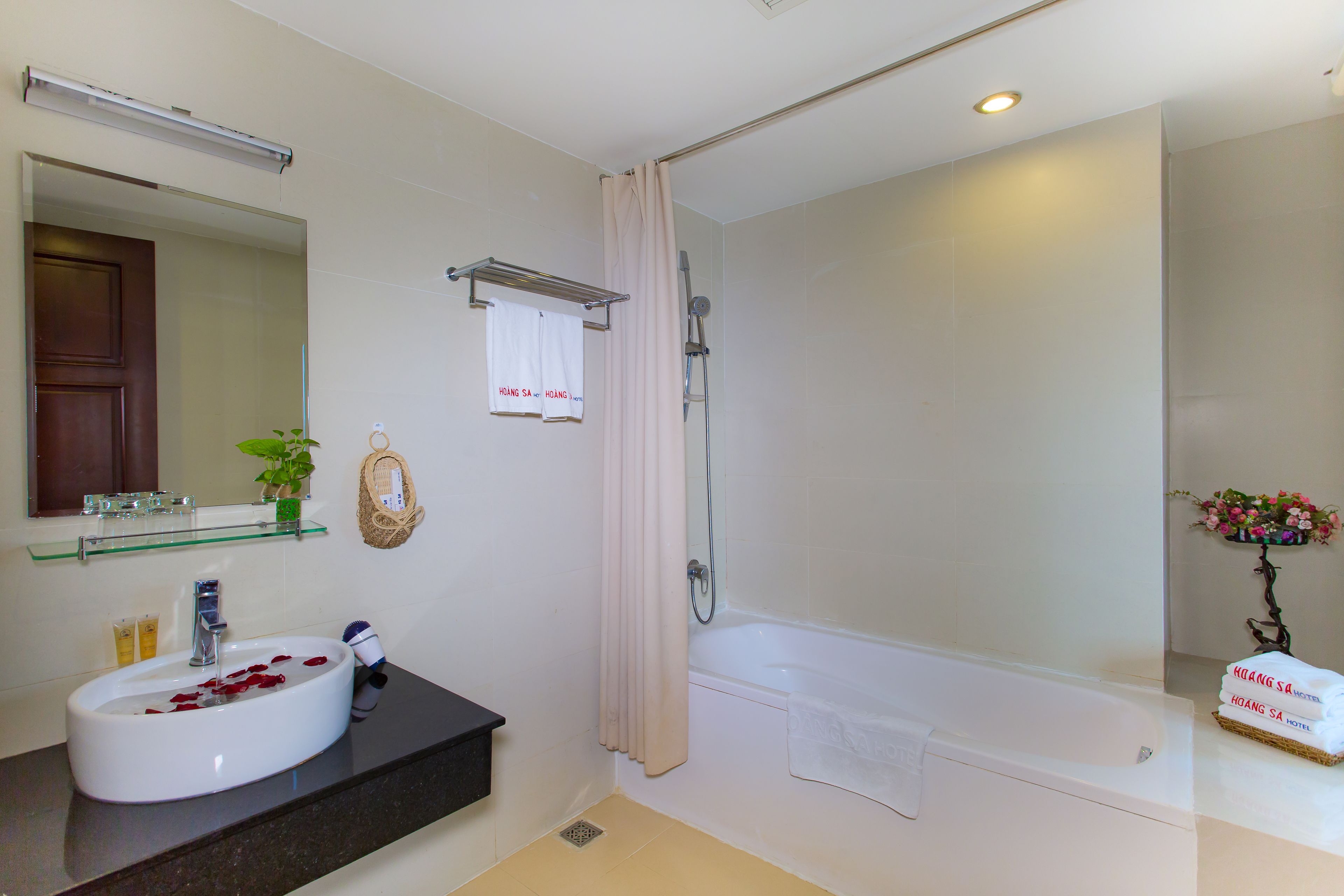 A bathroom with a sink, mirror, shower, and bathtub.