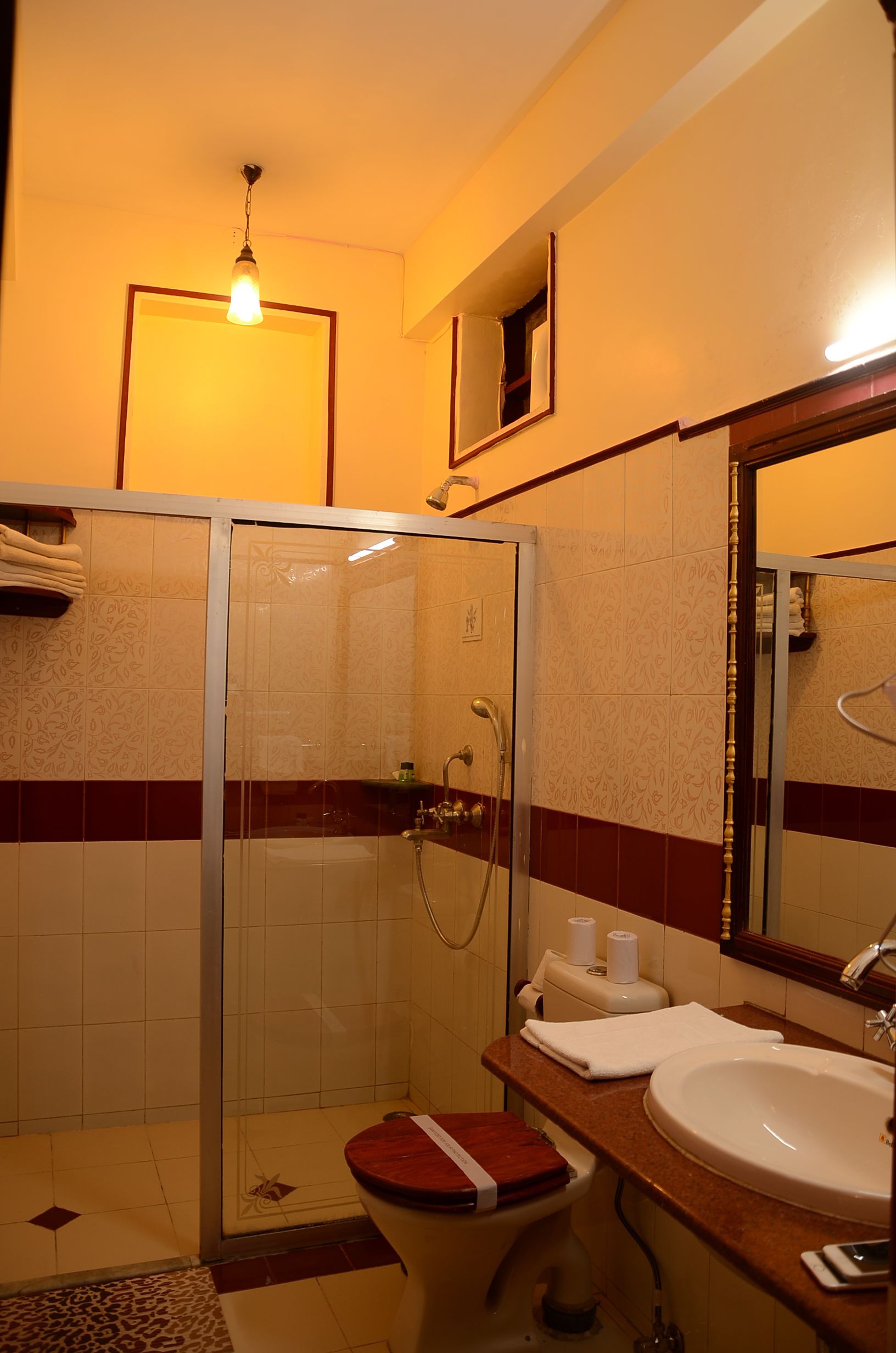 Un baño con cabina de ducha de vidrio, inodoro, lavabo y espejo.