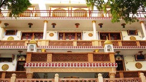 A multi-story building with ornate architectural details, including columns, decorative patterns, and balconies.