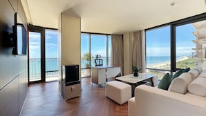 A modern hotel room with a large balcony, a dining area, and a sofa. - Holiday Beach Hotel Danang (Da Nang)