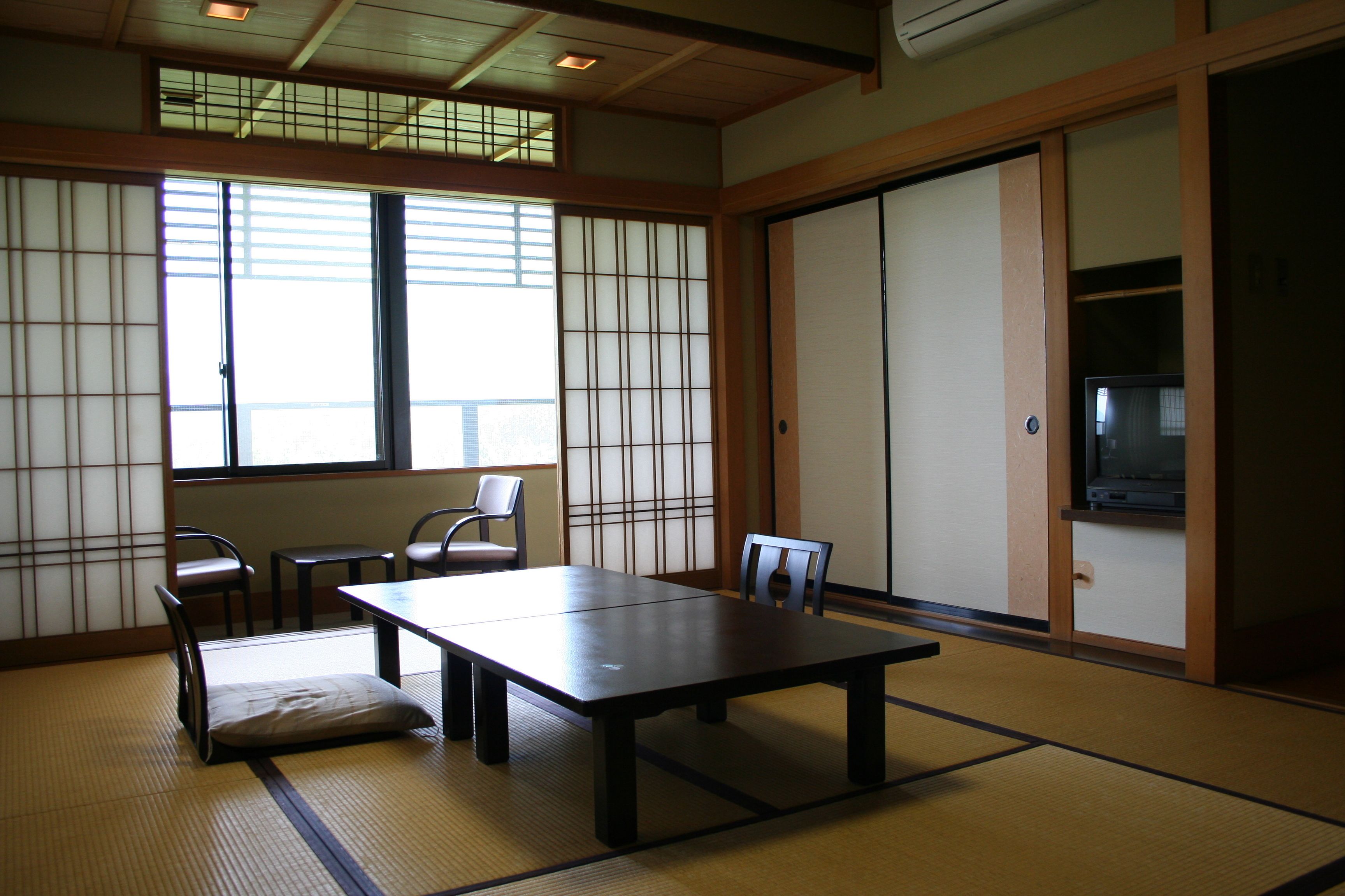 Ein traditioneller japanischer Raum mit Tatami-Böden, einem niedrigen Tisch und gleitenden Türen.