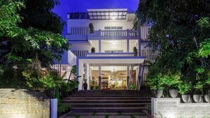 A multi-story building with a well-lit entrance, steps leading up to the door, and a sign indicating the name of the property. - Diamond D'Angkor Boutique (Siem Reap)