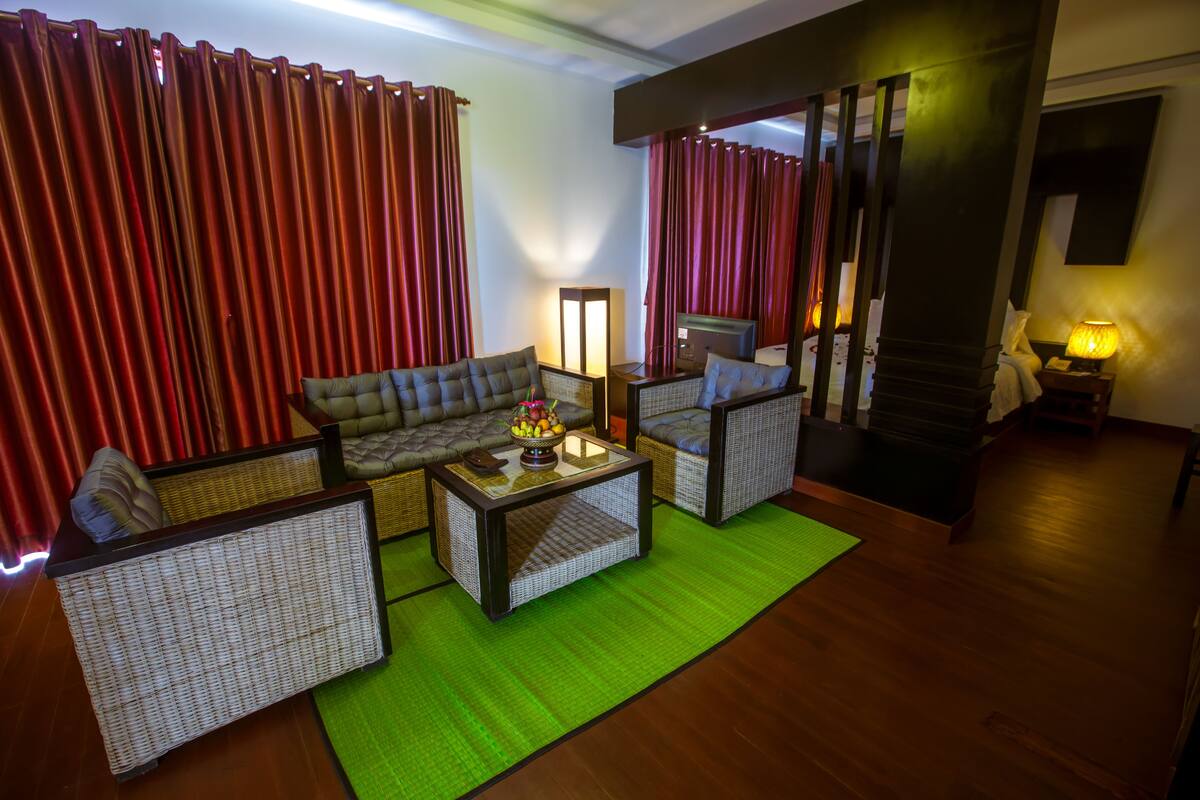 Una habitación con un sofá, dos sillones, una mesita de centro y una lámpara.