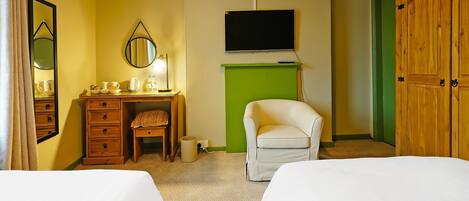 A hotel room with a bed, a desk, a chair, a television, and a wardrobe.