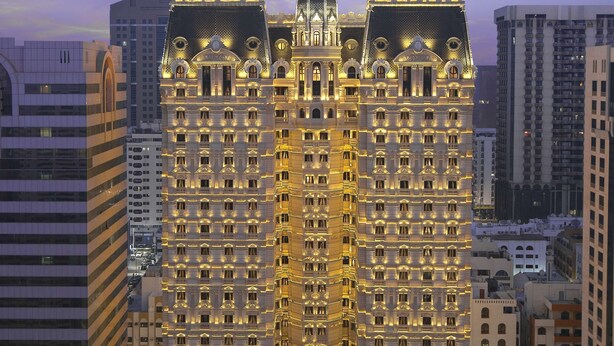 A high-rise hotel with a classic architectural style, featuring multiple balconies and a central dome.