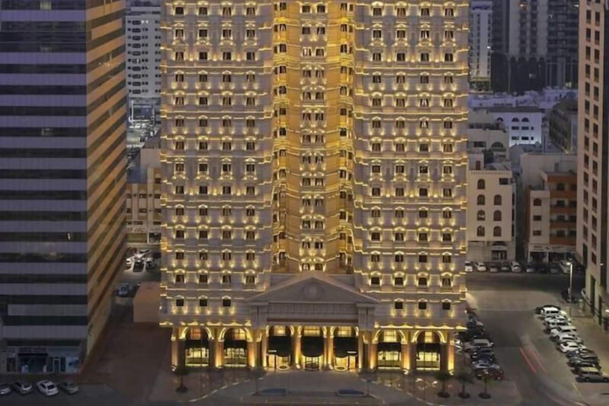 A multi-story hotel with a central dome and symmetrical facade, surrounded by other buildings.