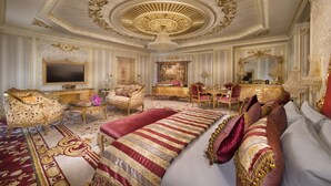A luxurious room with ornate ceiling, a large bed, and a desk with a chair. - Royal Rose Hotel Abu Dhabi, Curio Collection by Hilton (Abu Dhabi)