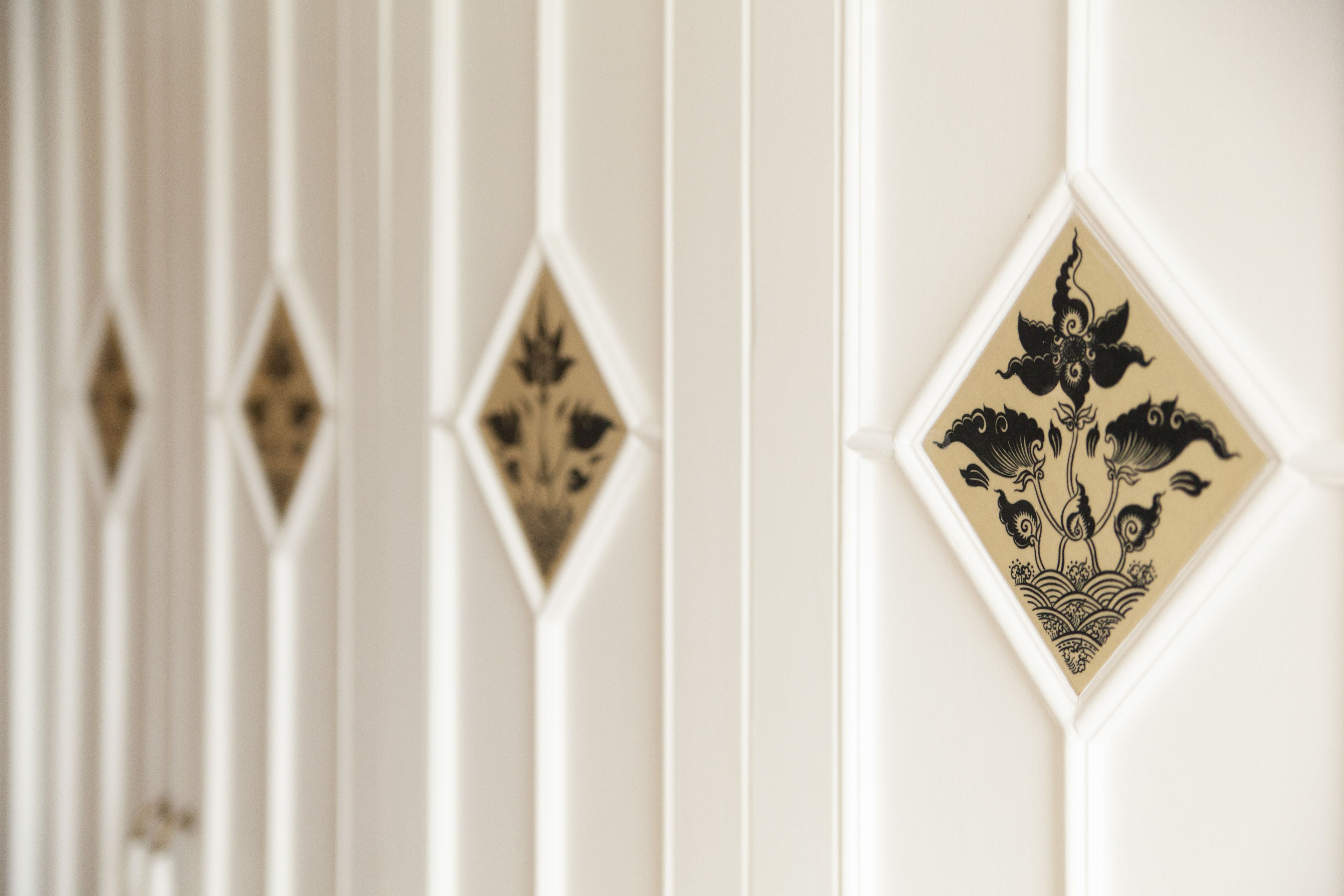 Un gros plan d’un mur orné de panneaux décoratifs aux motifs géométriques.