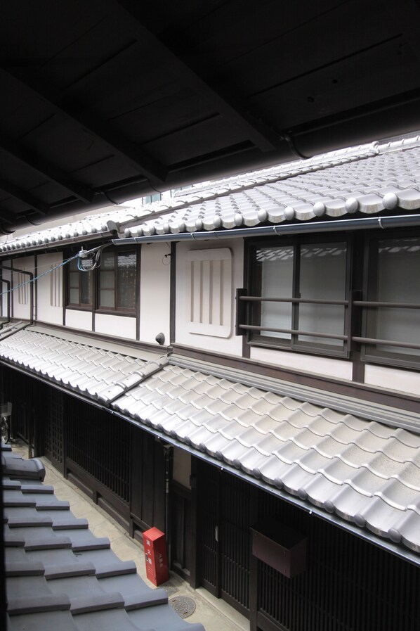 A traditional Japanese building with a tiled roof, wooden sliding doors, and a small red mailbox. - Kirakuan (Kyoto)