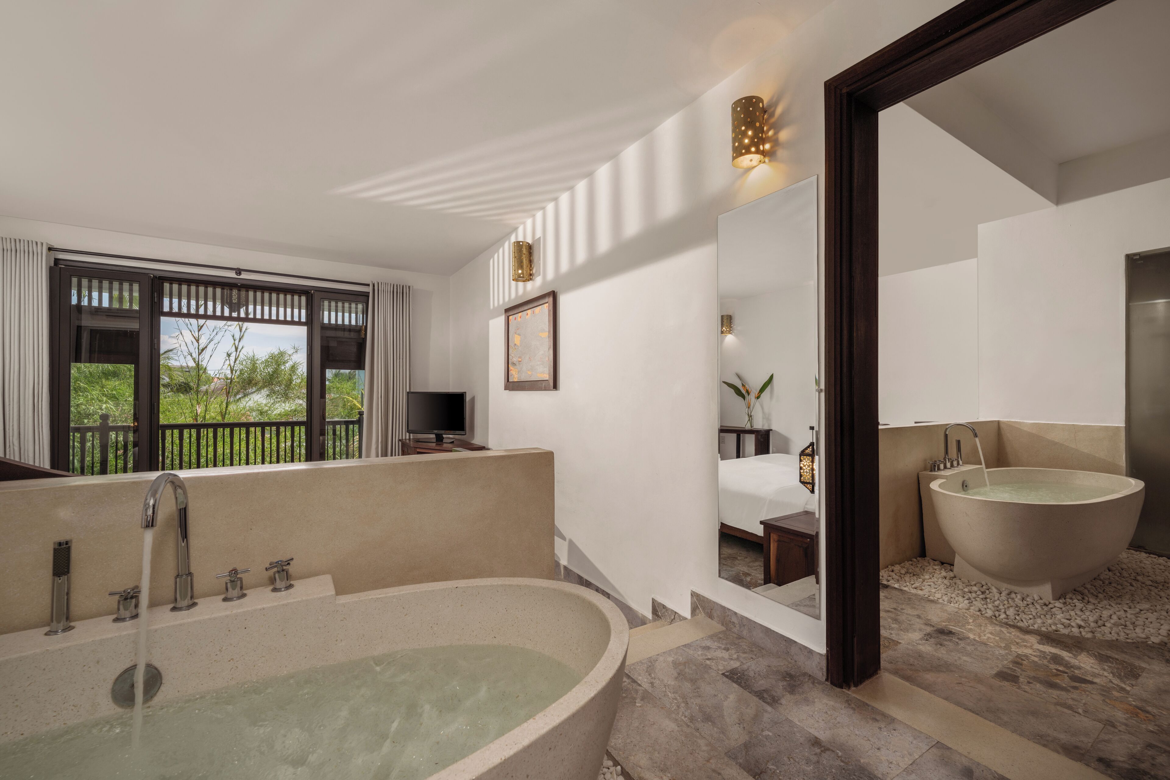 A modern bathroom with a large freestanding bathtub, a separate sink, and a shower area.