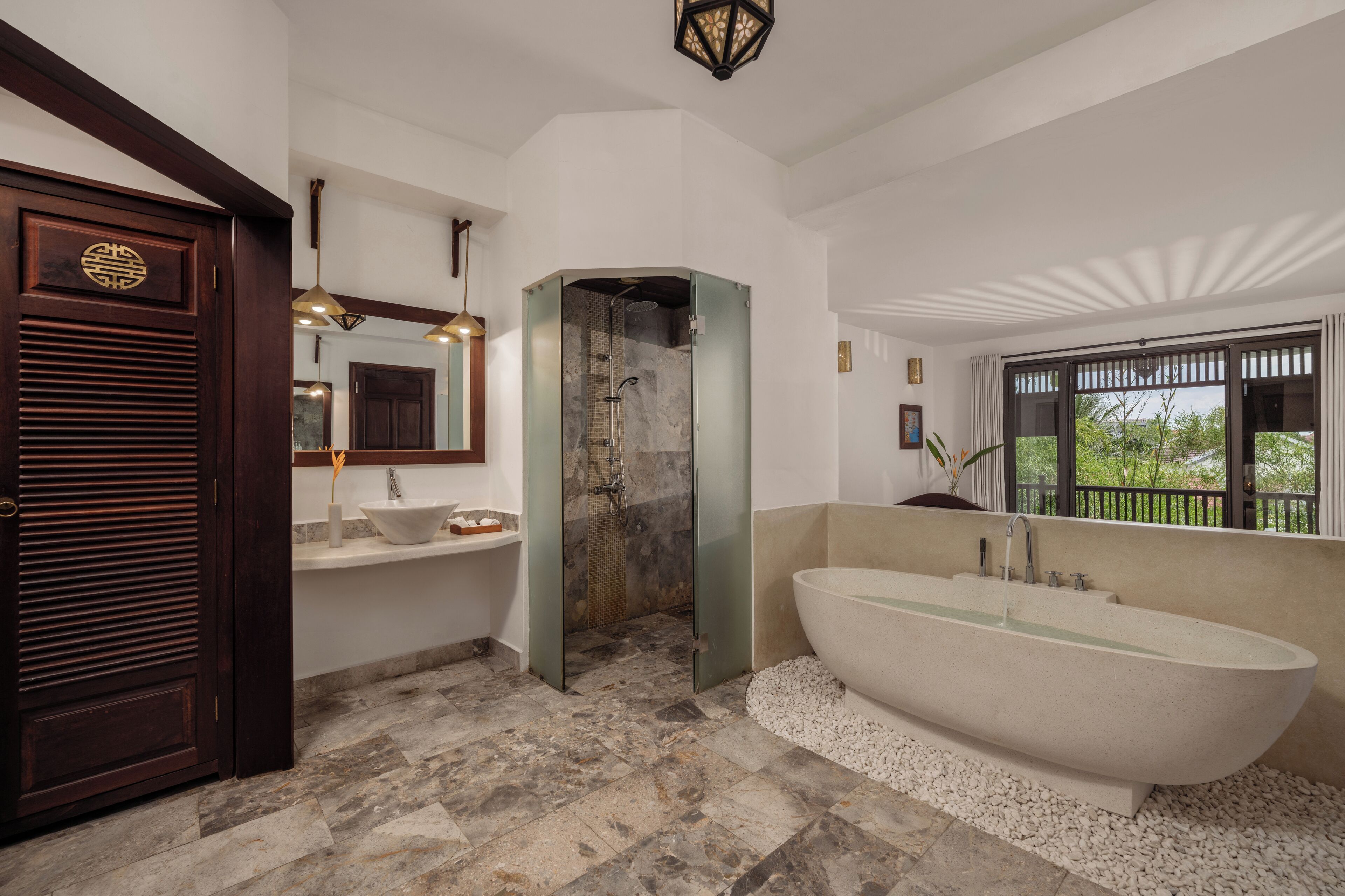 A modern bathroom with a freestanding bathtub, a glass-enclosed shower, and a large mirror.