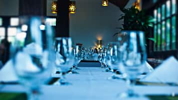 Una larga mesa dispuesta para un evento formal de cena, con varios vasos y cubiertos.