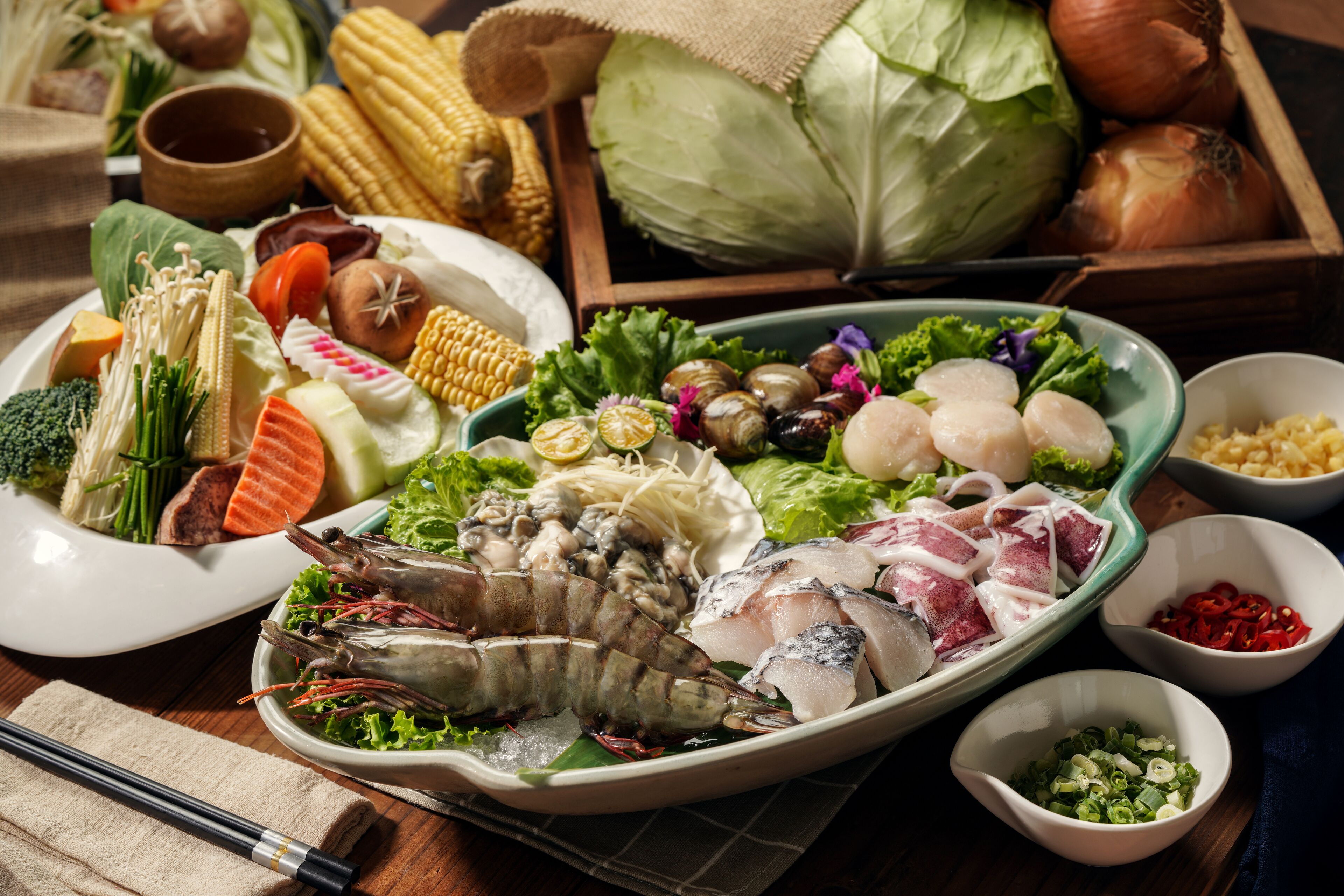A variety of fresh vegetables and seafood on a wooden table.