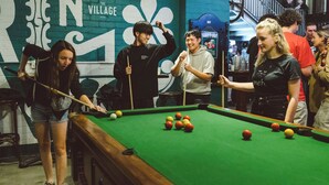 A pool table in a room with a green wall and a large flower design. - Little Drifter Melbourne (Melbourne)