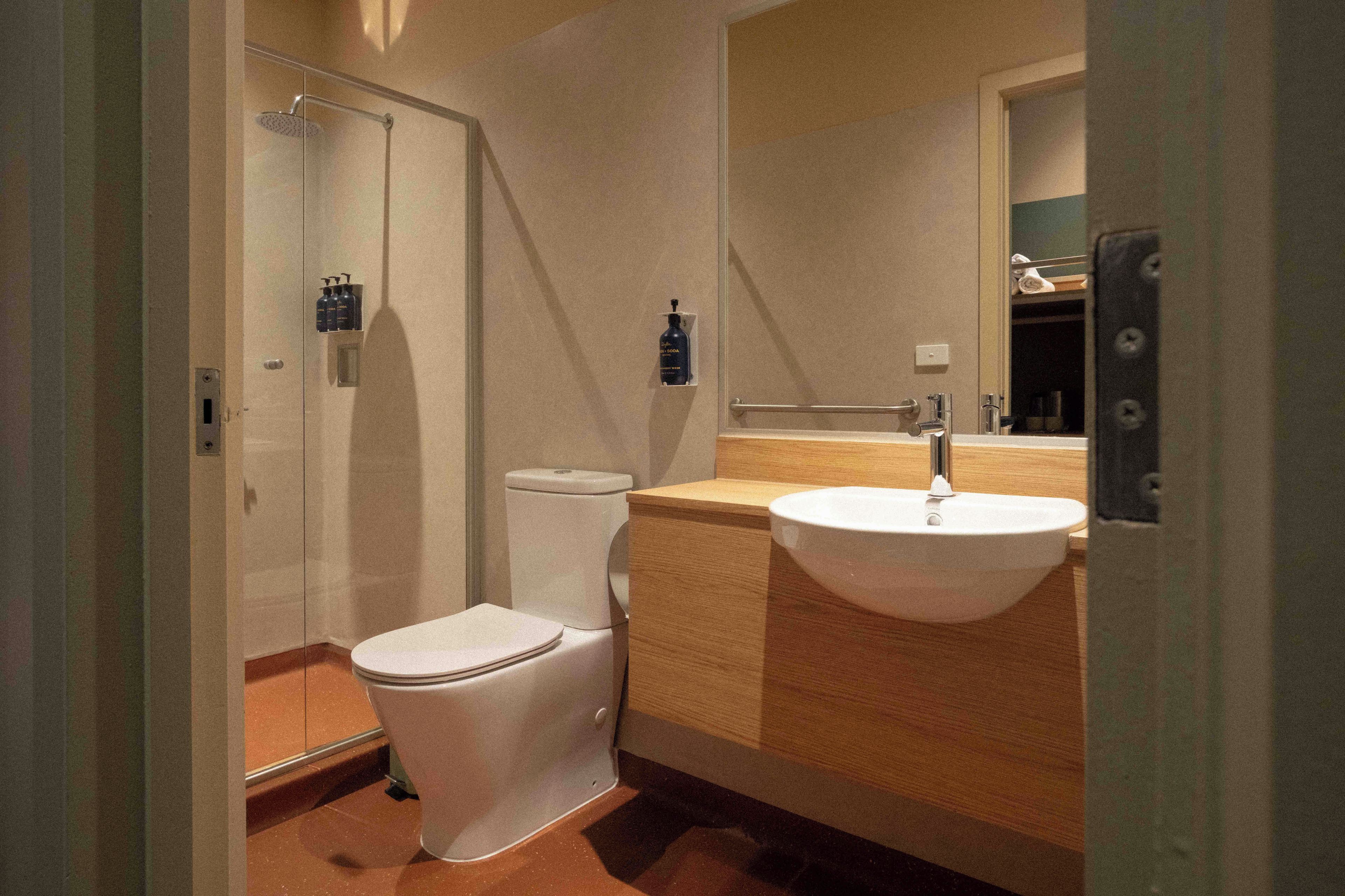 Une petite salle de bain comprenant des toilettes, un lavabo et une douche.