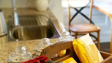 A kitchen counter with a wooden tray holding various food items and condiments.