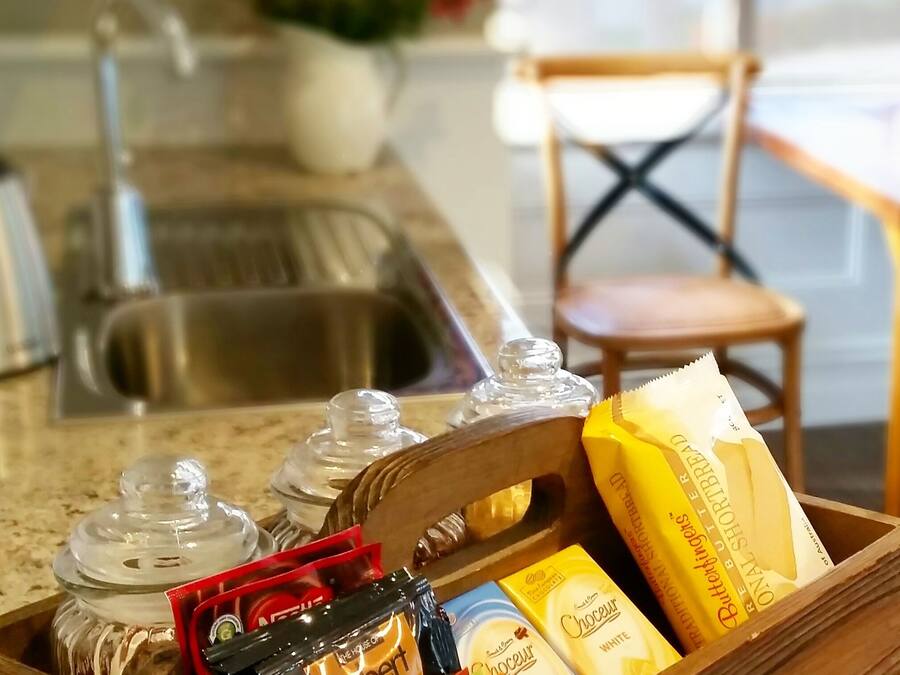A kitchen counter with a wooden tray holding various food items and condiments.