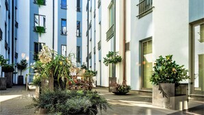 Un patio con plantas en macetas y una terraza de madera.