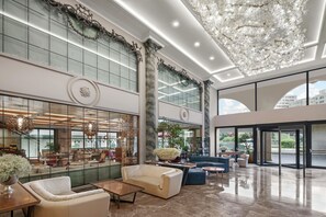A spacious lobby with a high ceiling, large windows, and modern furnishings. - DoubleTree By Hilton Istanbul Gayrettepe (Istanbul)
