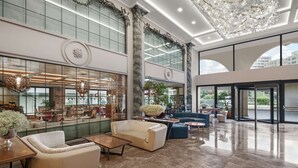 A spacious lobby with a high ceiling, large windows, and modern furnishings. - DoubleTree By Hilton Istanbul Gayrettepe (Istanbul)