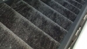 A carpeted staircase with white balusters and a black handrail. - Ashfield Bed & Breakfast (Kenmare)