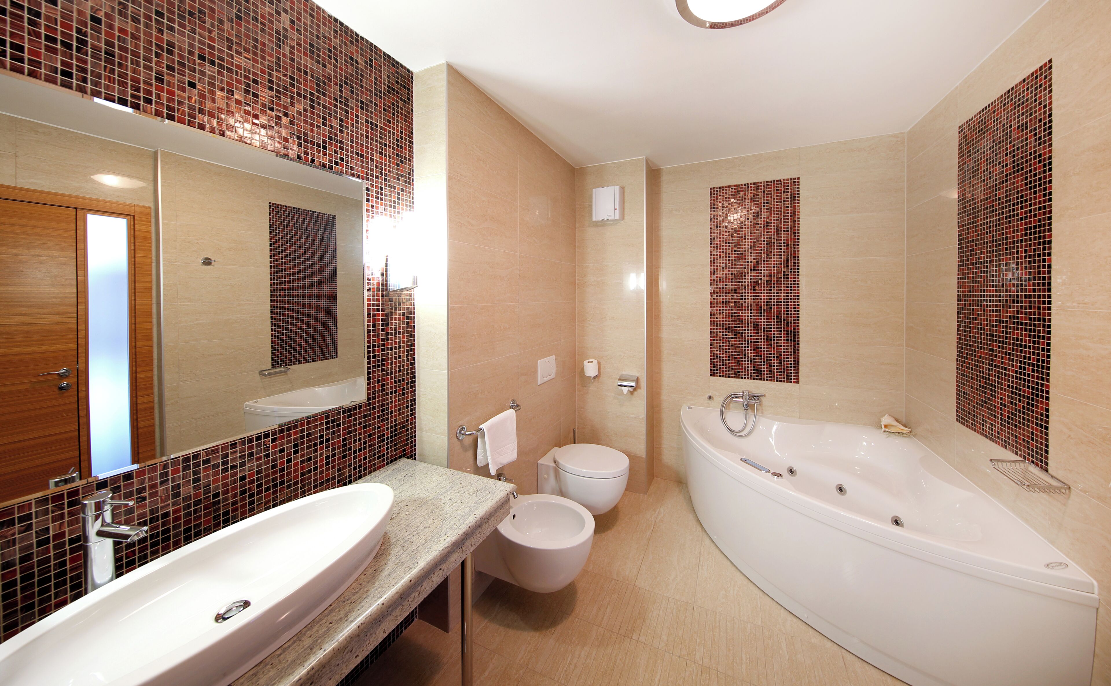 A bathroom with a large bathtub, a sink, and a toilet.