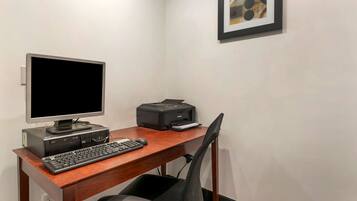 Ein Computertisch mit Bildschirm, Tastatur und Drucker.