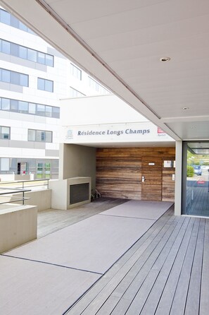 A modern building entrance with a sign reading "Résidence Longs Champs."