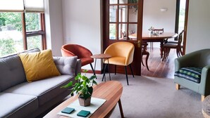 A living room with a sofa, armchairs, a coffee table, and a dining area with a table and chairs.