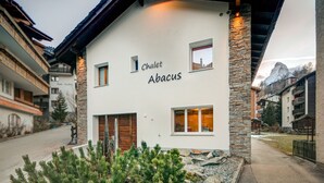 A building with the name "Chalet Abacus" on its facade, featuring stone accents and wooden elements. - Chalet Abacus (Zermatt)