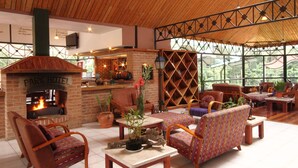 Un rincón tranquilo con chimenea de ladrillo, asientos cómodos y vistas al exterior.