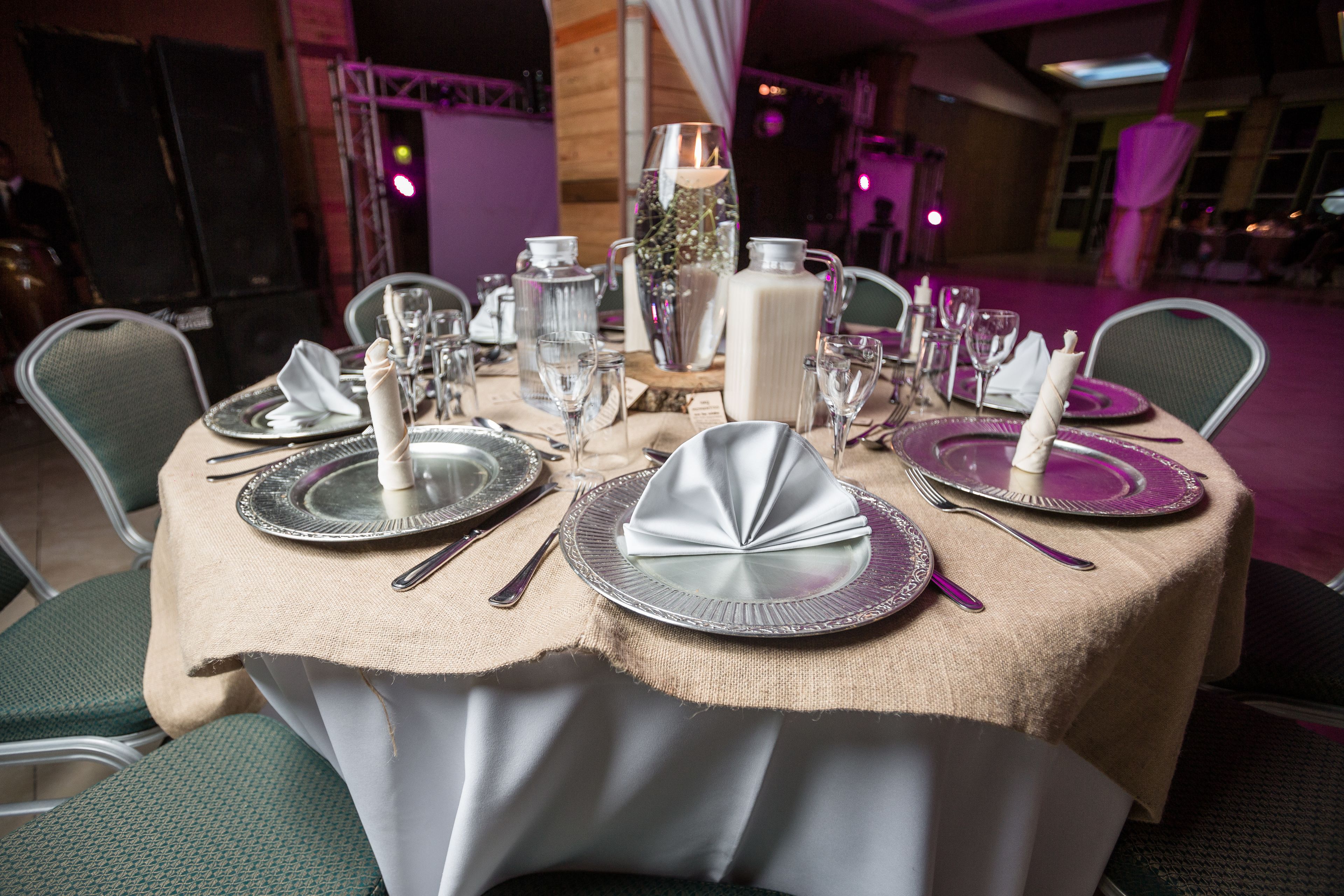 A table set for a formal dinner with silverware, plates, and glassware.